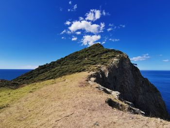 Scenic view of sea and mountains against blue sky