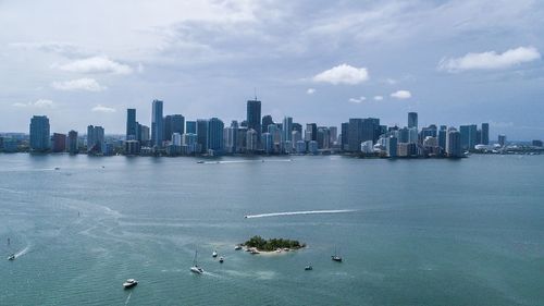 Sea by cityscape against sky