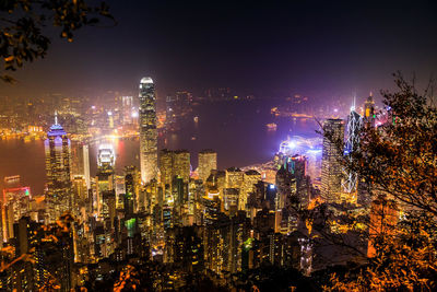 Illuminated cityscape against sky at night