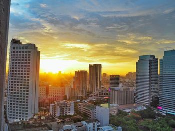 Skyscrapers in city at sunset