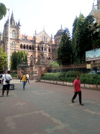 People walking on historical building in city