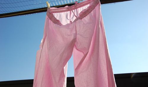 Low angle view of clothes hanging on clothesline against sky