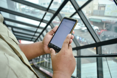 Midsection of man using mobile phone