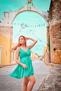 Full length of young woman standing against built structure in mexico