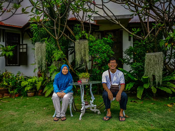 Portrait of couple sitting against house