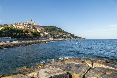 Scenic view of sea by buildings against sky