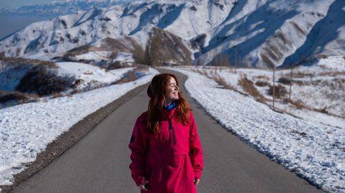Rear view of woman walking on snowcapped mountain