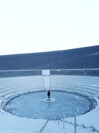 Man on snow covered landscape against clear sky