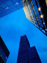 Low angle view of skyscrapers against blue sky