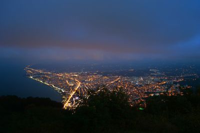 Aerial view of illuminated city against sky at night