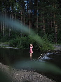 Rear view of woman standing in lake