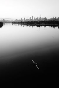 Scenic view of lake against sky in city