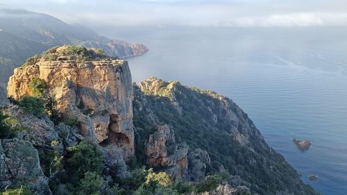 Scenic view of sea and mountains against sky