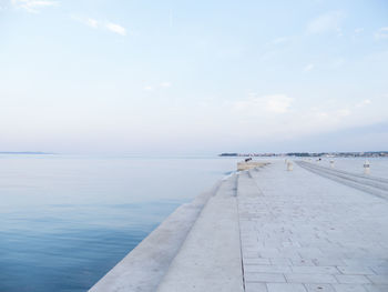 View of pier on calm sea against sky