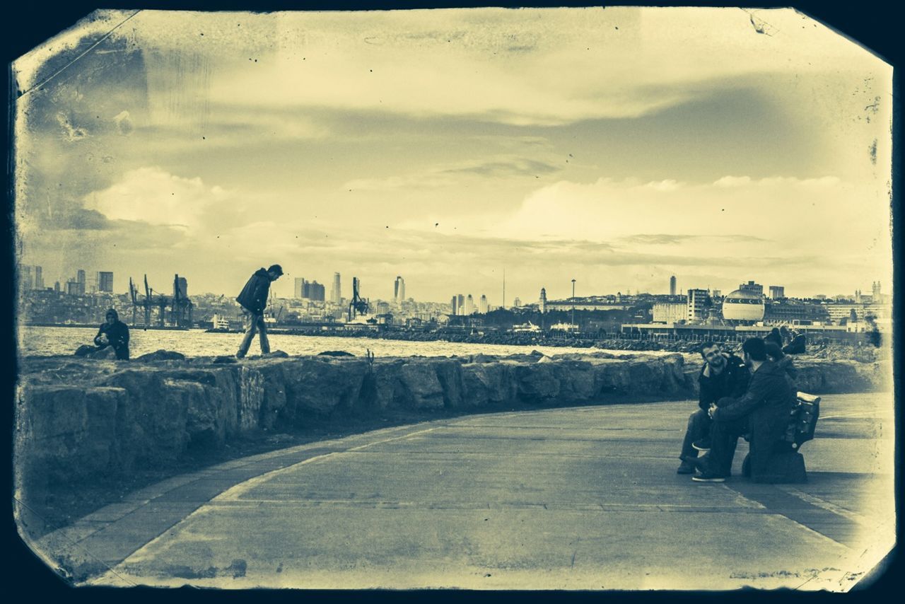 transfer print, sky, auto post production filter, men, lifestyles, cloud - sky, leisure activity, full length, transportation, person, architecture, built structure, walking, cloudy, cloud, street, building exterior, city, road