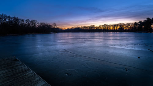 Scenic view of frozen lake against sky during sunset