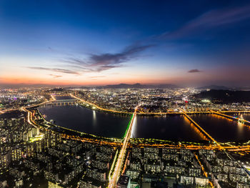 High angle view of illuminated city buildings at night