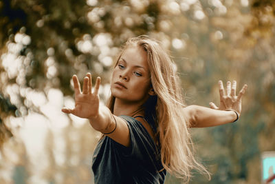 Portrait of young woman with arms raised