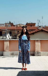 Young woman standing against building