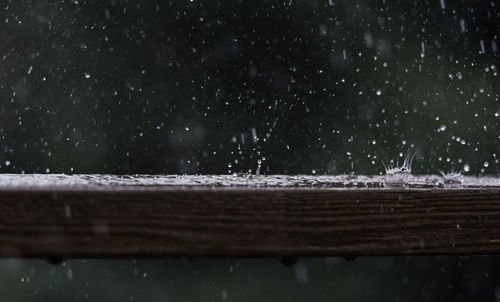 Close-up of water drops on railing