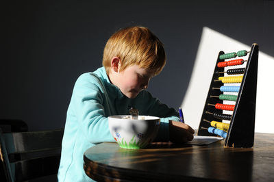 Boy with abacus doing homework at table