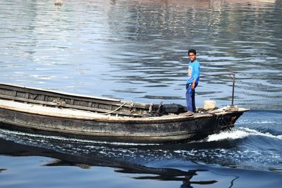 Man standing on boat in lake