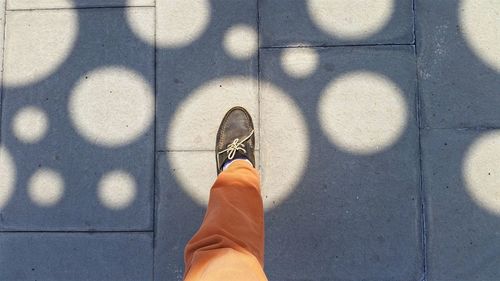 Low section of person standing on tiled floor