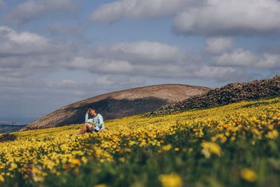 Scenic view of yellow flower on field against sky