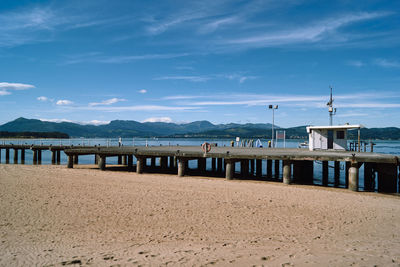 Pier on beach against sky