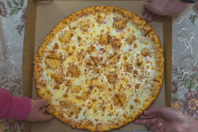 Close-up of hand holding pizza