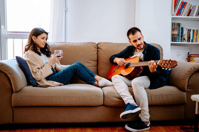 Friends sitting on sofa at home