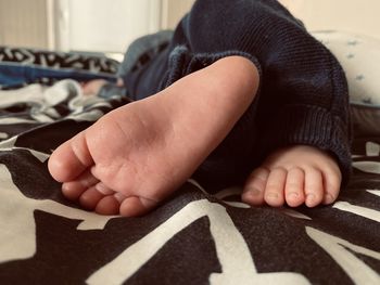 Low section of boy lying at home