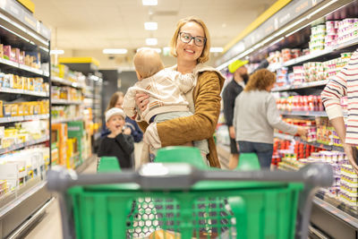 Portrait of young woman sitting in supermarket