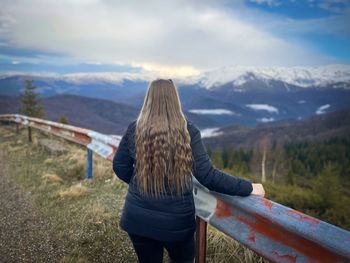 Rear view of woman standing on mountain