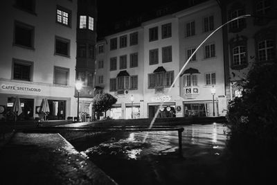 Buildings by street in city at night