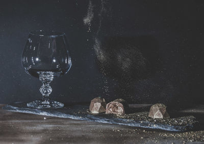 Close-up of glass on table against black background