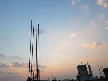 Low angle view of silhouette cranes against sky during sunset