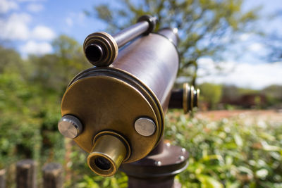 Close-up of coin-operated binoculars against sky