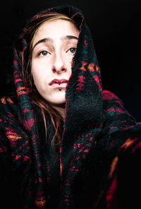 Portrait of a beautiful young woman over black background