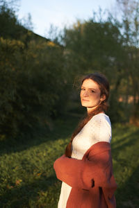 Portrait of smiling young woman standing on field