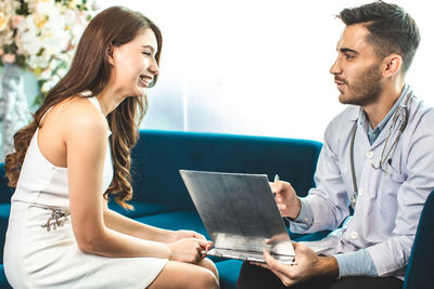 Young couple sitting in front of woman