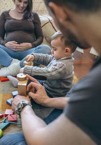 High angle view of father and daughter sitting on couch