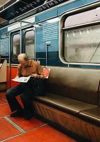 Rear view of man sitting in train