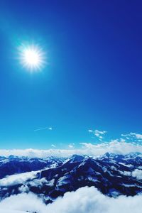 Scenic view of snowcapped mountains against blue sky