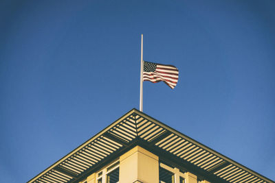 Low angle view of flag against clear blue sky