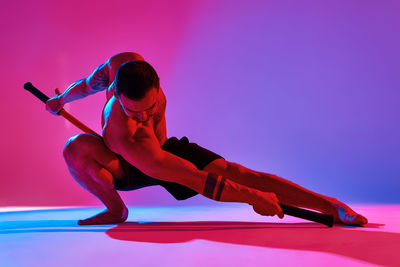 Low angle view of woman exercising against clear sky