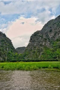 Scenic view of lake by mountain against sky