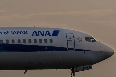 Text on airplane against sky at sunset