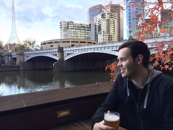 Man with bridge over river in city