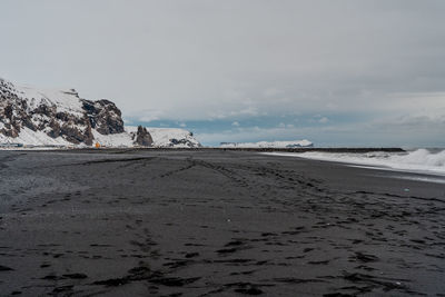 Scenic view of beach against sky during winter